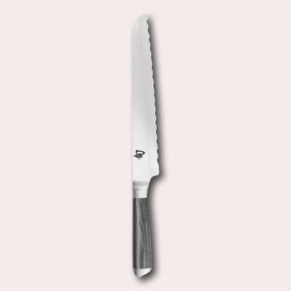 Kai Shun Kagerou Bread knife. 2 part blade of polished and dual-core Damascus Steel with a copper flash line.  Mottled grey pakkawood handle complete with a Shun logo end cap.
