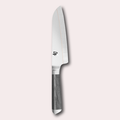 Kai Shun Kagerou Santoku knife. 2 part blade of polished and dual-core Damascus Steel with a copper flash line.  Mottled grey pakkawood handle complete with a Shun logo end cap.